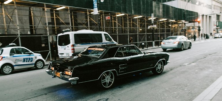 A dark vintage vehicle on its way to the long-term car storage.