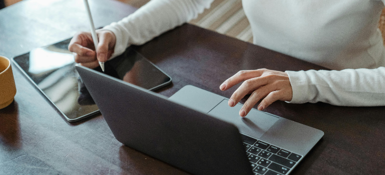 A person using a laptop and a tablet for making a plan for storage solutions