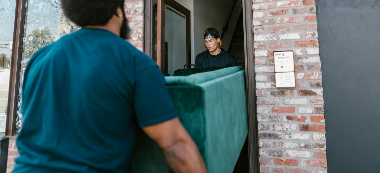 Professional movers carrying a couch.