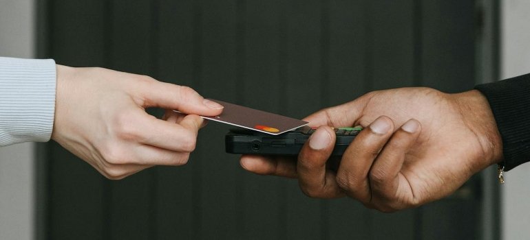 A person swipes a card on a payment terminal.
