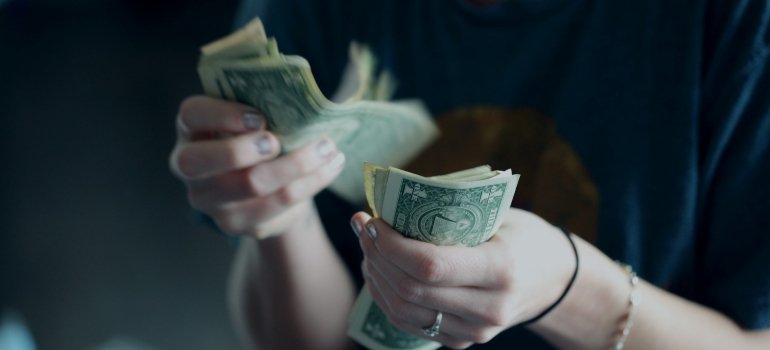 Person counting money for long-term storage in Long Island City.