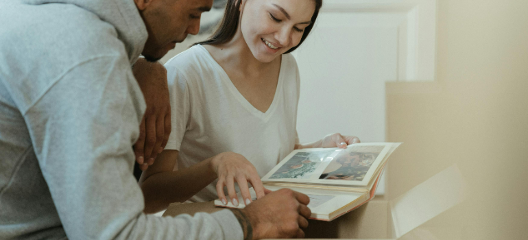 A couple looking at pictures of raising a family in Queens.