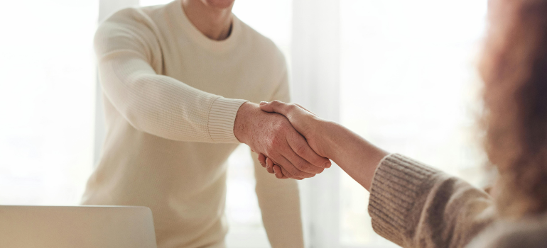 Two people shaking hands after comparing storage rental needs.