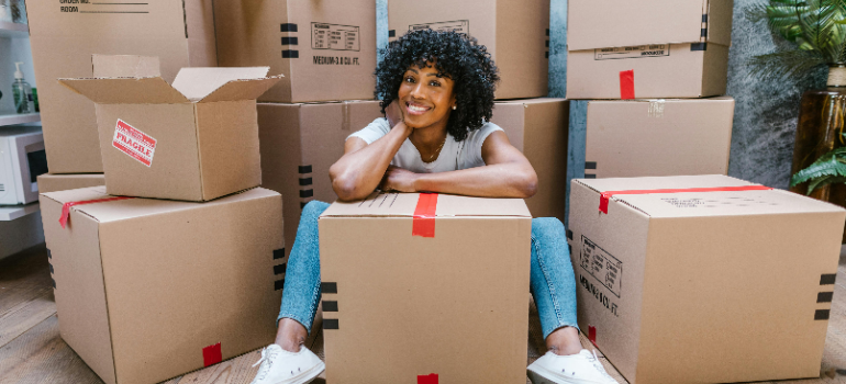 A woman packing items into cardboar boxes for storage as she has decided to choose a mini storage unit