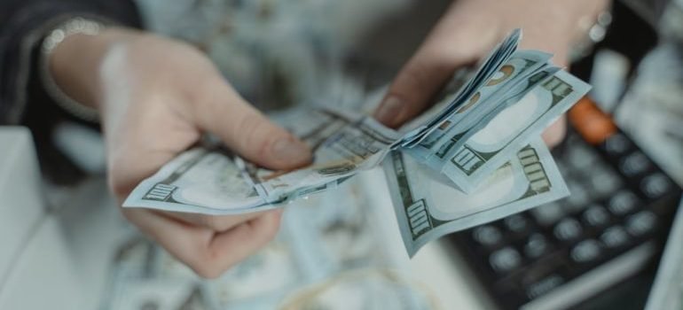 A person counting money and wondering why a climate controlled unit matters.