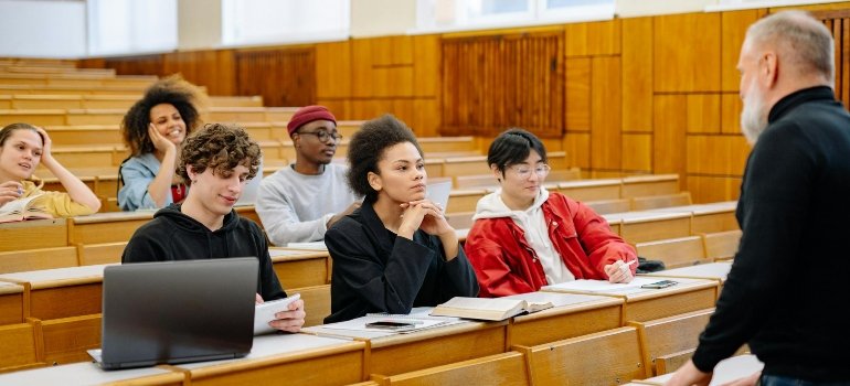 Students attentively listening in a college classroom, avoiding common student storage mistakes by keeping organized.