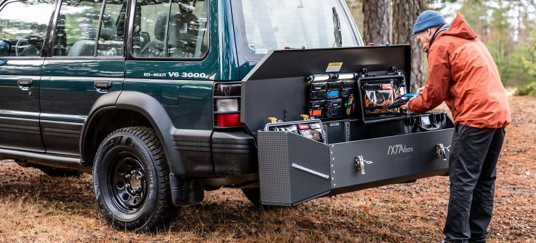 A man is working on the maintenance of his vehicle and thinking about vehicle storage safety.