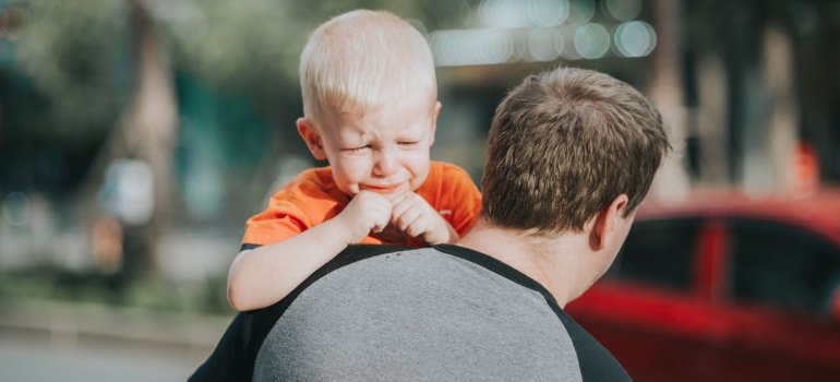 Adult holding a crying kid.