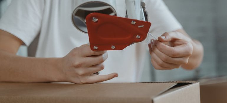 A person taping a box.