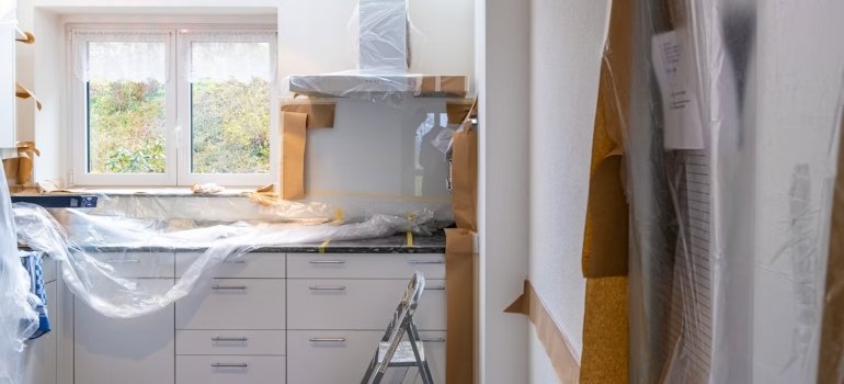 A kitchen with white cabinets and a ladder