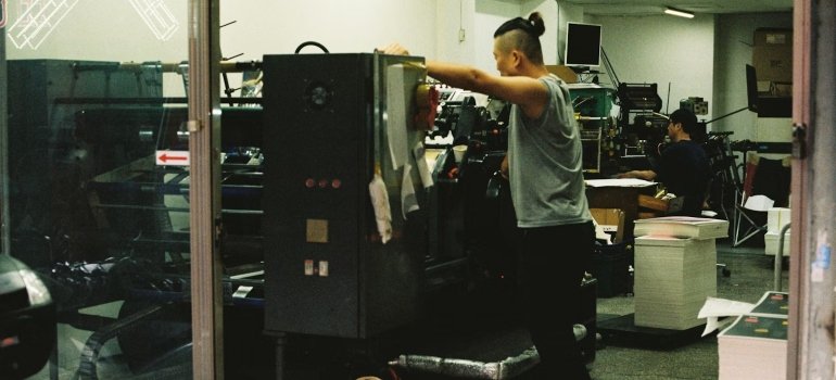 A man disassembling a large machine, one of the tips when you pack and store large furniture
