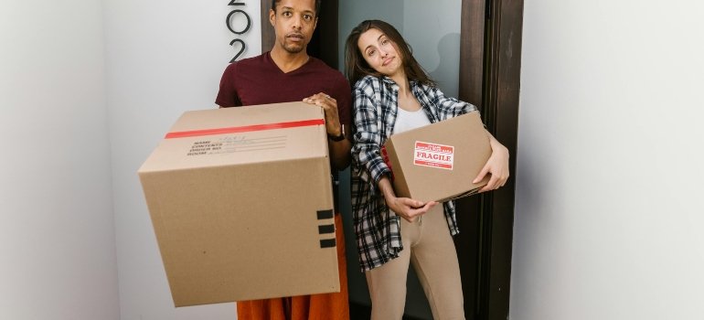 a couple holding boxes thinking about benefits of storage companies that offer pickup services