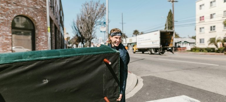 a man holding an enormous green bed