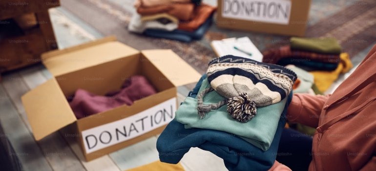 A person sorting clothes into boxes