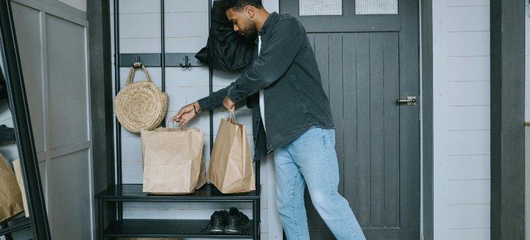 a man holding bags and putting shoes in storage