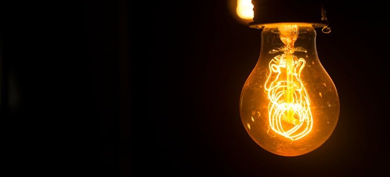 a light bulb glowing in the dark, you need to maintain the bulbs in your apartment, as one of the fundamental apartment makeovers to boost your sale price