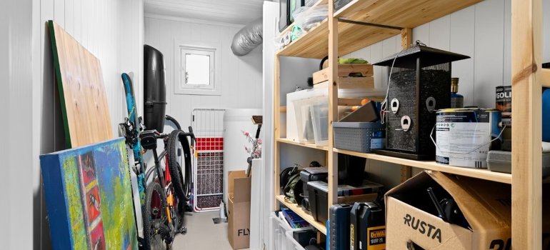A room with a bike, shelves and stored items