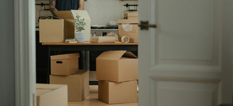 Kitchen filled with cardboard boxes during moving day, part of the Storage Checklist for New Homeowners.