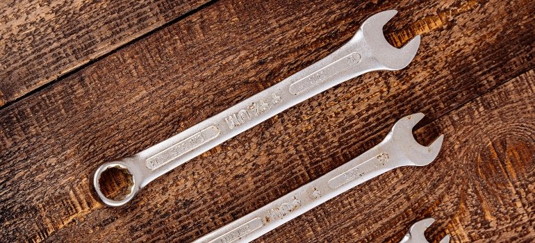 Set of silver wrenches on a wooden table, ready for home repairs.