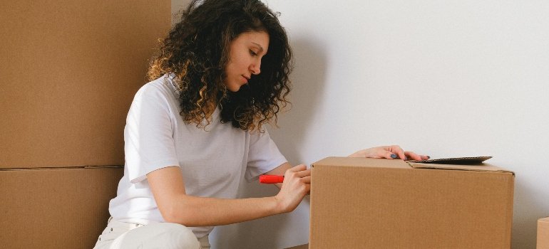 Woman Writing Labels on Brown Box
