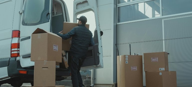 a boy packing the boxes in the van