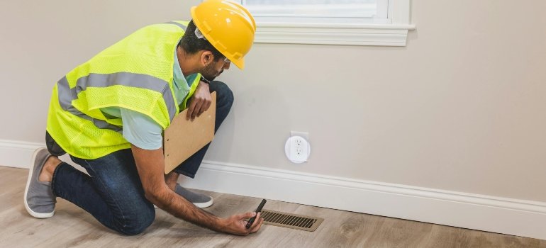 A man is checking the walls and thinking about repairs before renting out your Bronx apartment.