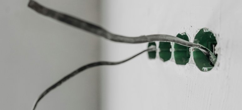 The wires hanging out of the wall.