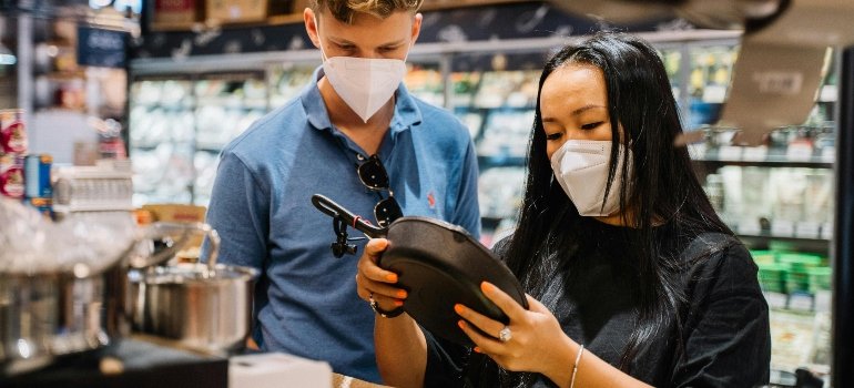 a couple in the shop pondering how to deal with stored items before leaving NYC
