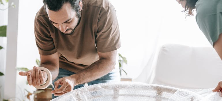 A couple packing a chair by using packing tips for climate controlled storage