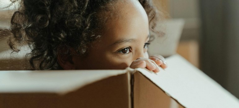 A child peeking from inside a box.