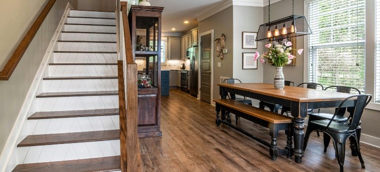 Wooden furniture and stairs in a dining room showing how to maximize space with under stairs storage.
