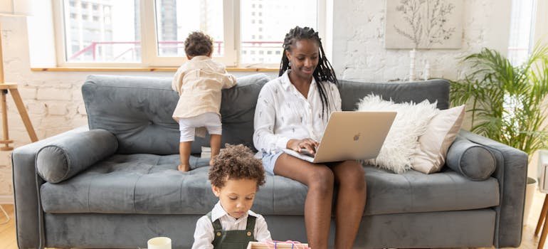 A mother using laptop to research the reasons Bronx families use storage during a move
