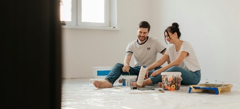 A happy couple painting their new home together, adding warmth and personality to their space.