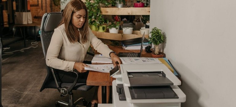 Woman Sitting on Chair and make a copies of documents.