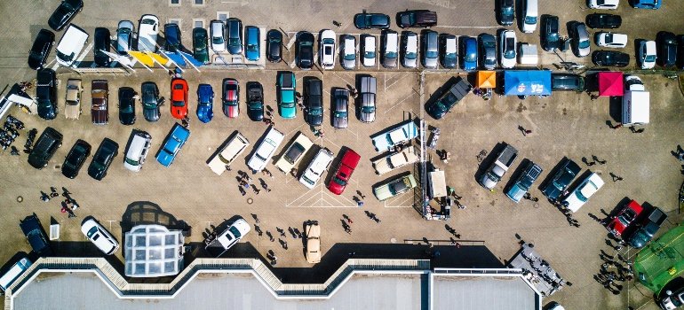 Aerial photo of a busy parking lot with multiple cars parked side by side.