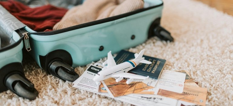 An open suitcase with passports and toy airplane.