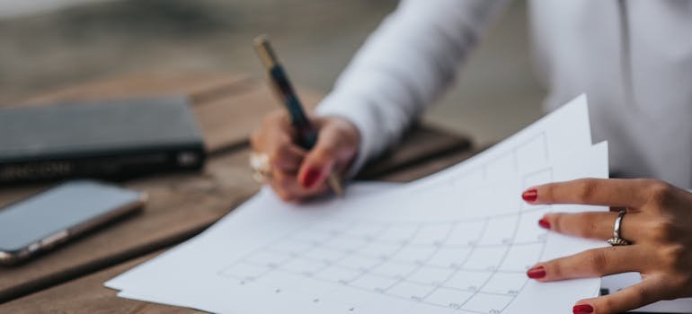 A woman writing on the paper about short term vs long term storage for business needs