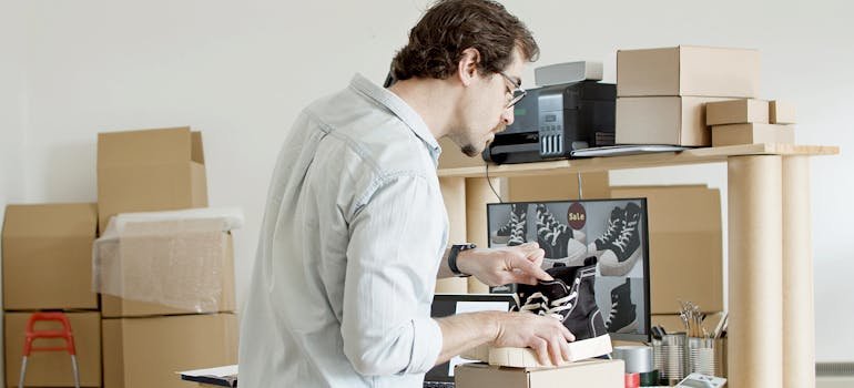 A man packing shoes in the box
