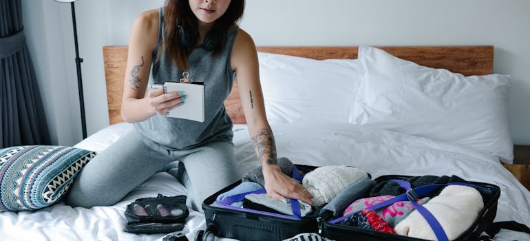 A woman holding a paper with packing tips for college students