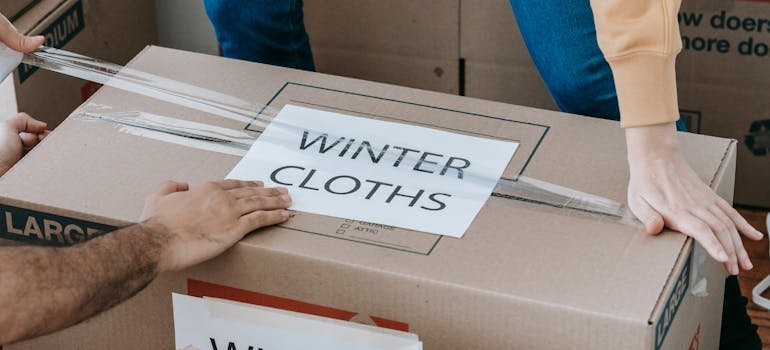 A couple sealing a moving box and having a winter move in the Bronx