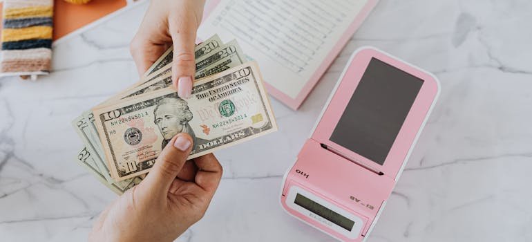 Two people holding dollar bills