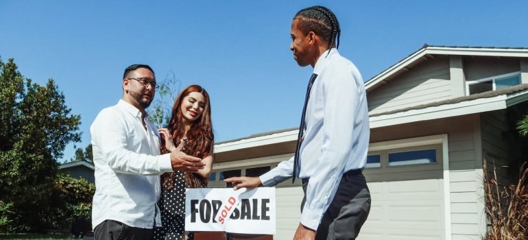 Two people talking with the real estate agent about the reasons people use short term storage