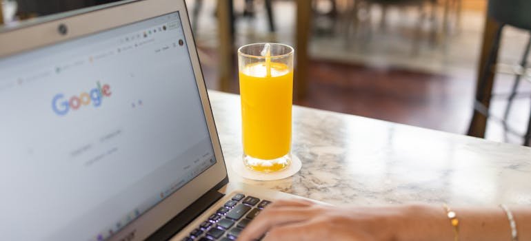 A person using laptop to compare indoor vs outdoor car storage