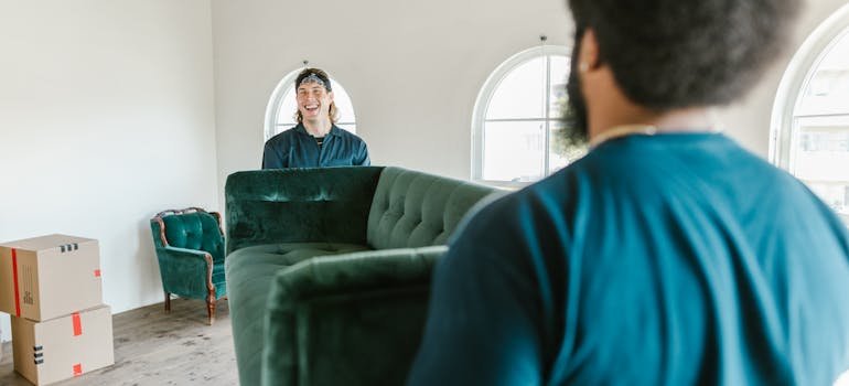 Two movers holding a sofa helping with moving from Manhattan to Long Island City