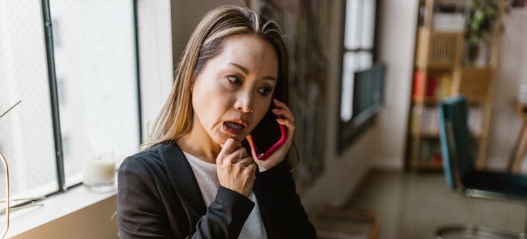 A woman talking on the phone in order to prepare for your first apartment move in NYC