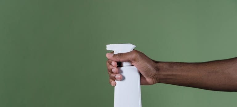 A person holding a bottle for cleaning