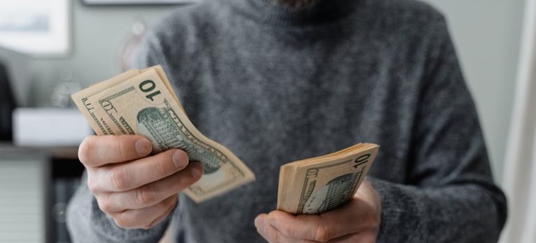A person counting dollar bills