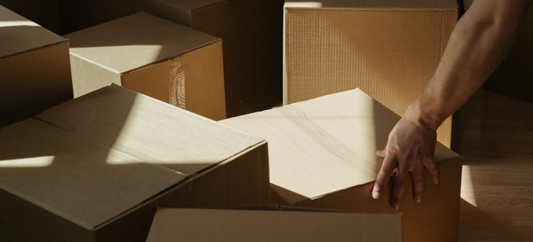 A person using moving boxes for packing a Manhattan studio for storage