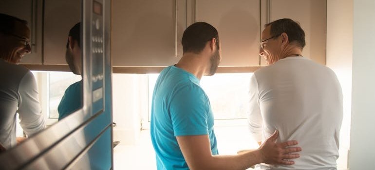 Two roommates who share a tiny New York apartment in the kitchen