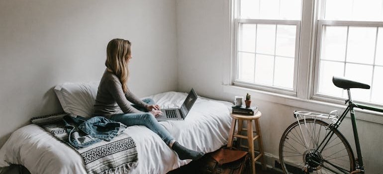 A woman using laptop to research living in the Bronx as a student